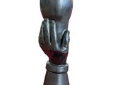 un vase en métal orné d'une main, sur fond blanc