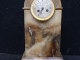 a clock that is sitting on a marble stand