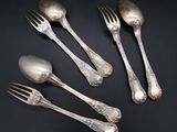 five silver spoons and a fork on a black surface