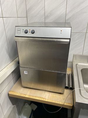 stainless steel dishwasher and sink in a kitchen with tiled walls