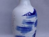a blue and white vase sitting on a white surface