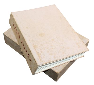 three books stacked on top of each other on a white surface