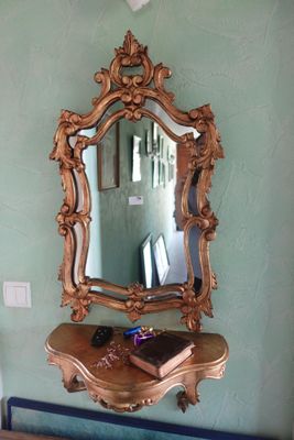 un miroir accroché au mur au-dessus d'une table sur laquelle se trouve un livre
