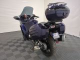 a blue motorcycle parked in a room with a checkered floor