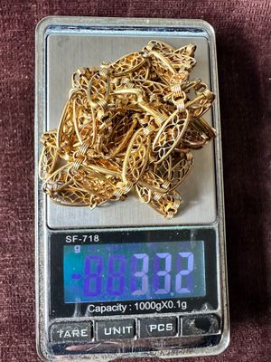 une petite balance sur laquelle repose un tas d’or