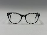 des lunettes « œil de chat » tachetées de noir et blanc posées sur une surface blanche