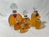 trois flacons de parfum posés l'un à côté de l'autre sur une surface blanche