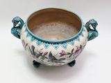a ceramic bowl with a handle on a white background