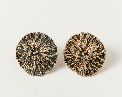 a pair of gold and black earrings on a white background