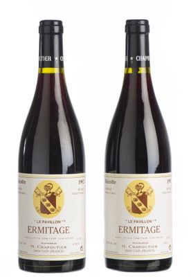 deux bouteilles de vin posées l'une à côté de l'autre sur une surface blanche