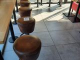 Plusieurs tabourets sont alignés devant une table dans un restaurant