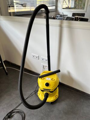 un aspirateur jaune posé par terre dans la pièce