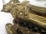 a gold clock that is sitting on top of a table