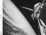 photographie en noir et blanc d'une navette spatiale en orbite, avec la Terre en arrière-plan