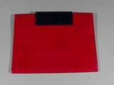 a red purse with a black handle on a white table