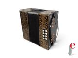 an image of a black and gold accordion sitting on top of a white surface