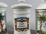 three ceramic containers with different designs on them sitting on a table
