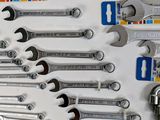 many wrenches that are on the wall of a garage