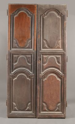 une paire de portes anciennes en bois avec des panneaux sculptés