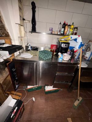 a dirty kitchen with a lot of clutter on the floor