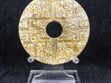 a gold plate on a clear stand on a black background