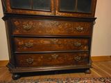 a wooden dresser with a glass door and a rug on the floor