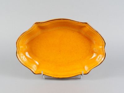an orange plate on a metal stand on a white surface
