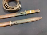 two knives and a belt laying on a table