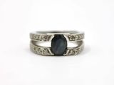 a close up of a ring with a black stone on it