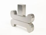 a metal object on a white surface with a white background