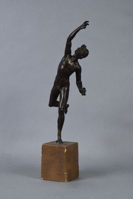 bronze statue of a man holding a tennis racquet on a wooden base