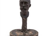 statue of a man ' s head on a wooden base