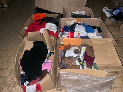 de nombreux cartons de vêtements posés les uns à côté des autres sur le sol