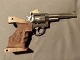 un revolver avec un manche en bois sur une table