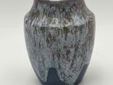 a close up of a vase on a white surface