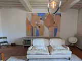 a white couch in a living room with a painting on the wall behind it