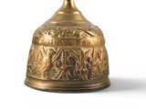 a gold bell that is sitting on a white surface