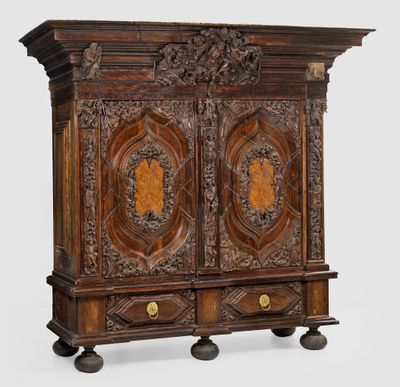 une vieille armoire en bois avec des sculptures et des gravures sur les portes