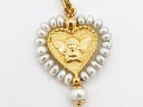 une image représentant un pendentif en forme de cœur en or, orné de perles et d'une perle