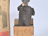 a statue of a man sitting on a box next to a book