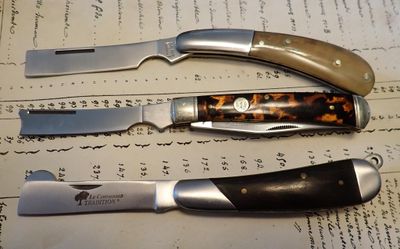 deux couteaux et un aiguiseur posés sur une feuille de papier