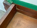 a wooden bench with a green cushion on top of it