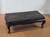 a black coffee table with a floral design on it