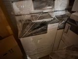 une pile de cartons, les uns empilés sur les autres, posée sur le plan de travail de la cuisine