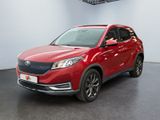 Le SUV rouge est garé dans une pièce au sol noir.