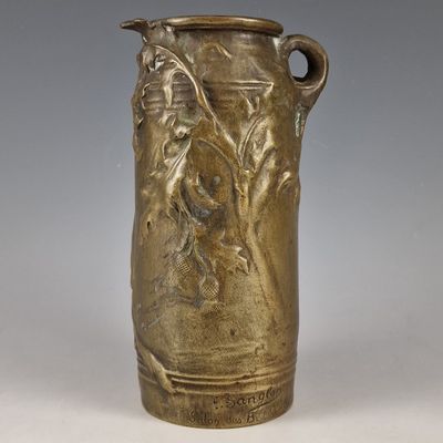 un vase antique en bronze orné d'une femme et d'un oiseau