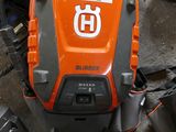 an orange and black chainsaw sitting on the floor next to other tools