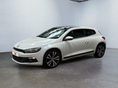 Une Volkswagen Golf blanche est garée dans une grande pièce.