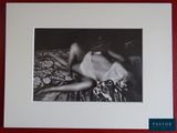 a black and white photo of a woman laying on a bed