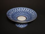 a blue and white bowl with a candle in it